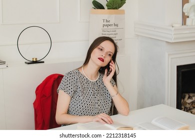 Beautiful business woman sitting at the table and talking on the phone - Powered by Shutterstock