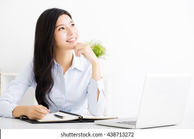 Beautiful business woman thinking while working on computer at office