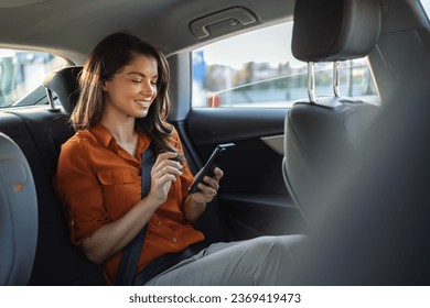 Beautiful Businesswoman is Commuting from Office in a Backseat of Her Luxury Car. Entrepreneur Passenger Traveling in a Transfer Taxi in Urban City Street - Powered by Shutterstock