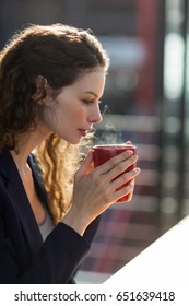 Beautiful businesswoman drinking cup of coffee in office - Shutterstock ID 651639418
