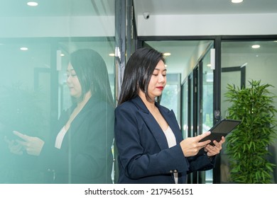 Beautiful Businesswoman Looking Down At Her Digital Tablet. Office Setting.