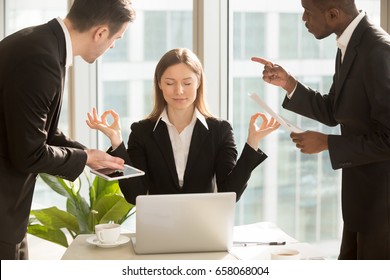 Beautiful businesswoman meditating at workplace, ignoring work, not listening to annoying clients or bothering colleagues talking to her, sitting at office desk with eyes closed, keep calm, no stress - Shutterstock ID 658068004