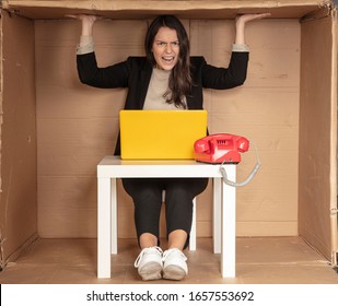 beautiful businesswoman sits in a tight paper office, needs more space