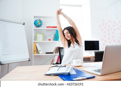 Beautiful businesswoman stretching hands in office - Shutterstock ID 410726191
