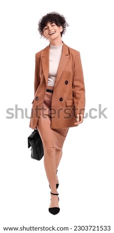 Beautiful businesswoman in suit with briefcase walking on white background