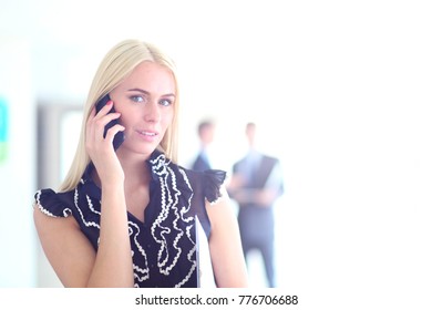 Beautiful businesswoman using cell phone , standing in office . - Shutterstock ID 776706688