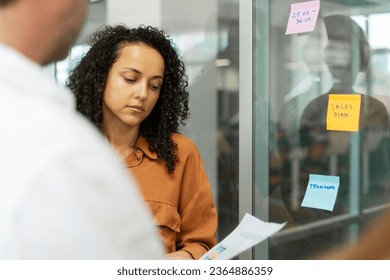 Beautiful businesswoman using sticky notes, agile methodology for productivity working in modern office. Successful scrum master planning strategy, startup, talking, brainstorming. Teamwork, scrum - Shutterstock ID 2364886359