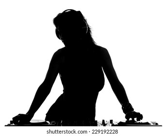 Beautiful busty DJ with her headphones is standing at her deck mixing sound.