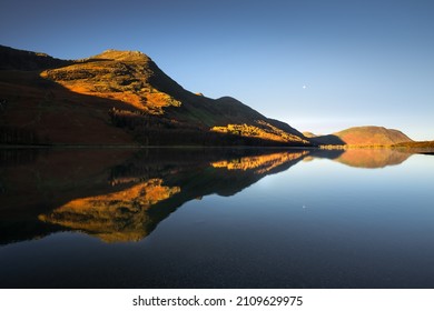 Beautiful Buttermere reflections with blue sky on a peaceful morning in the Lake District. Golden Autumn landscape with stunning mountains. UK scenic views. - Powered by Shutterstock