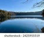 Beautiful and calm lake scene with bright blue sky and a treelined shore. Green Lakes, Syracuse New York.  New York State Park. 