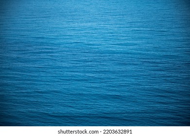 Beautiful Calm And Peaceful Water Flowing With Waves Towards Beach With Green Tall Trees Against Cloudy Blue Sky During Daytime With No People Around