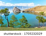 Beautiful calm summer landscape of Siberian Baikal Lake. Rock Shamanka - a natural landmark of Olkhon Island attracts tourists