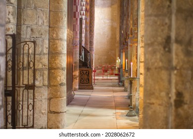 Beautiful Candle Light In Ancient Roman Church Side-aisle With Old Painted Stone Walls And Columns