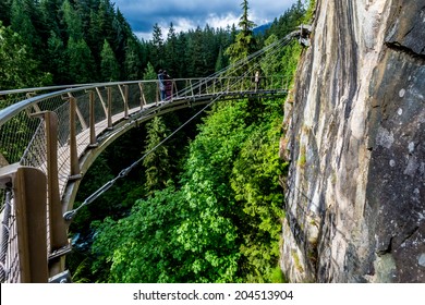 Beautiful Capilano Cliff Walk Suspension Bridge with Tourists Enjoying the View, in Vancouver. - Powered by Shutterstock