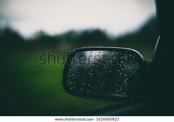 Beautiful car\
mirror with water droplets and\
bokeh