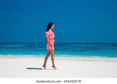 Beautiful Carefree Woman Enjoying Exotic Sea, Brunette Relax On Tropical Beach At Summer Holiday. Attractive Girl In Red Dress Resting. Bliss Freedom Concept.