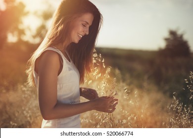 Beautiful carefree woman in fields being happy outdoors