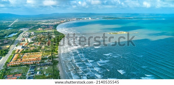 Beautiful Caribbean road\
with palm trees along the coast of Venezuela, Tucacas hotel zone,\
aerial view.