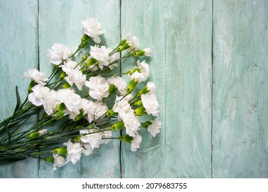 beautiful carnations on turquoise wooden surface