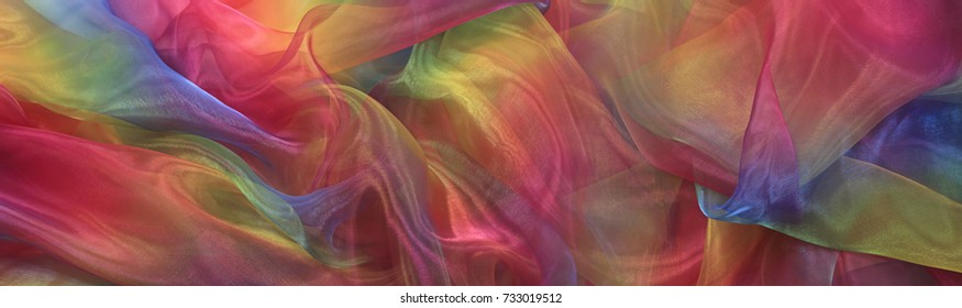 Beautiful Cascading Rainbow Chiffon Banner Background - Wide shimmering rainbow colored chiffon material cascading in gentle folds 
