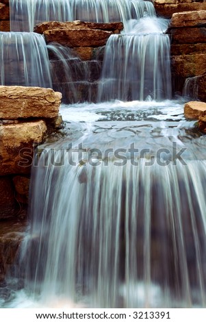 Beautiful cascading waterfall over natural rocks, landscaping element