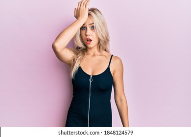 Beautiful Caucasian Blonde Girl Wearing Sexy Party Dress Surprised With Hand On Head For Mistake, Remember Error. Forgot, Bad Memory Concept. 