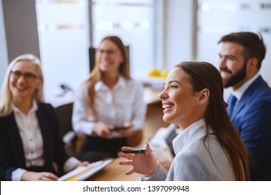 Beautiful Caucasian brunette sitting at meeting with pen in hand and discussing about project. The meaning of life is to find your gift. The purpose of life is to give it away. - Shutterstock ID 1397099948