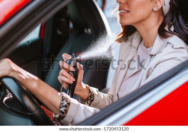 Beautiful
caucasian businesswoman puts perfume in
car