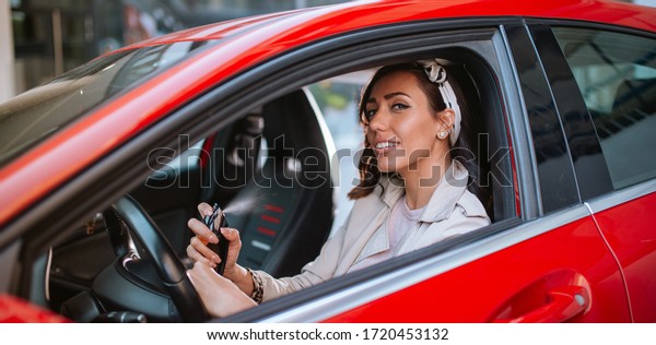 Beautiful\
caucasian businesswoman puts perfume in\
car