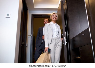 beautiful caucasian couple entering hotel room, young man and woman in elegant wear happy to have trip, vacation together