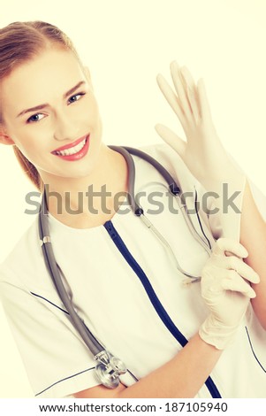 Beautiful caucasian doctor or nurse putting white sterile glove.