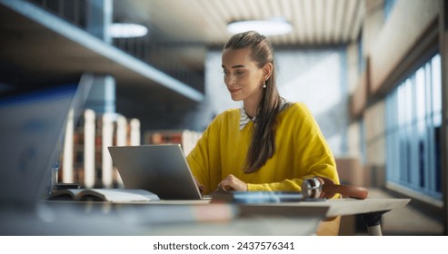 Beautiful Caucasian Female Student Working on Her College Degree Thesis on a Laptop Computer in Library. Young Stylish Female in a Yellow Jumper Studying an Online Course Alone in a Reading Hall - Powered by Shutterstock