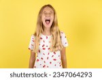 beautiful caucasian kid girl wearing polka dot shirt angry and mad screaming frustrated and furious, shouting with anger. Rage and aggressive concept.