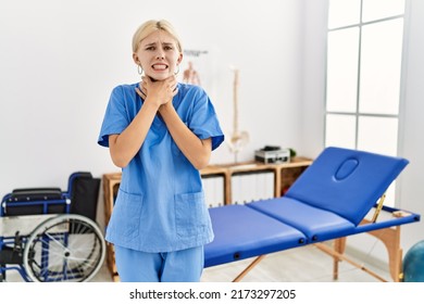 Beautiful caucasian physiotherapist woman working at pain recovery clinic shouting and suffocate because painful strangle. health problem. asphyxiate and suicide concept. 