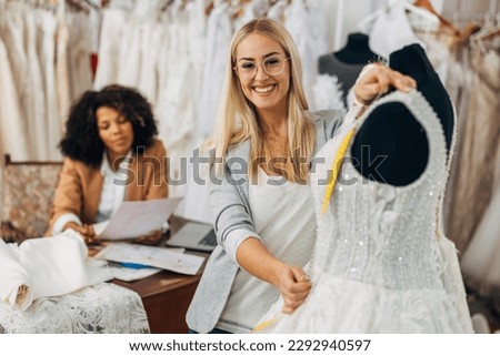 A beautiful caucasian tailor measures upper part of a wedding dress