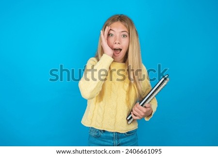 beautiful caucasian teen girl  with scared expression, keeps hands on head, jaw dropped, has terrific expression. Omg concept
