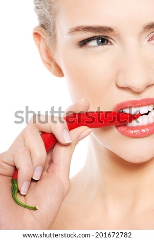 Beautiful caucasian topless woman with chili pepper in mouth. Isolated on white.
