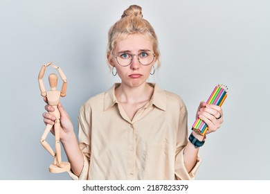 Beautiful caucasian woman with blond hair holding small wooden manikin pencils depressed and worry for distress, crying angry and afraid. sad expression.  - Powered by Shutterstock