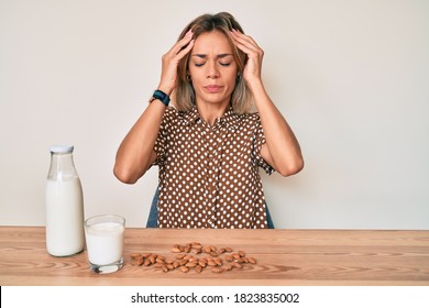 Beautiful Caucasian Woman Drinking Healthy Almond Milk With Hand On Head, Headache Because Stress. Suffering Migraine. 