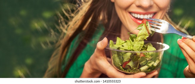 Beautiful caucasian woman eating salad over green natural background - Shutterstock ID 1410555323