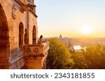 Beautiful caucasian woman enjoying morning view over Parliament in Budapest from Fisherman Bastion balcony