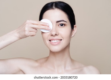 Beautiful Caucasian Woman Gently Cleaning Face With Makeup Remover Pad On Beige Background