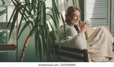 Beautiful caucasian woman sipping morning coffee while concentrating reading a book in her living room. Lady studying textbook. Person spending time resting in - Powered by Shutterstock
