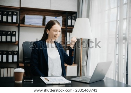  Beautiful Caucasian woman using laptop and tablet while sitting at her working place. Concentrated at work.
