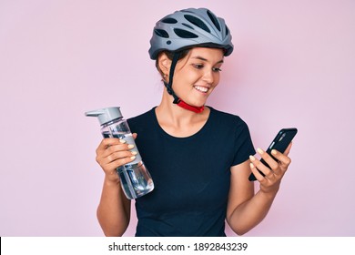 Beautiful caucasian woman wearing bike helmet looking at smartphone smiling with a happy and cool smile on face. showing teeth. 
