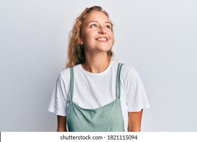 Beautiful caucasian woman wearing casual clothes looking away to side with smile on face, natural expression. laughing confident. 