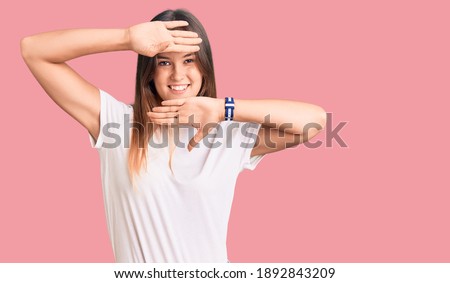 Beautiful caucasian woman wearing casual white tshirt smiling cheerful playing peek a boo with hands showing face. surprised and exited 