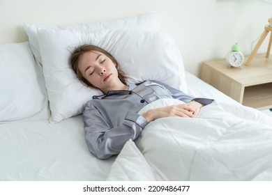 Beautiful Caucasian Woman Wearing Pajamas Sleeping In Bedroom At Home. Attractive Tired Young Female Laying Down On Bed With Blanket Feeling Happy And Relax Body After Finish Work In Morning At House.