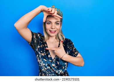 Beautiful Caucasian Woman Wearing Princess Crown Smiling Making Frame With Hands And Fingers With Happy Face. Creativity And Photography Concept. 