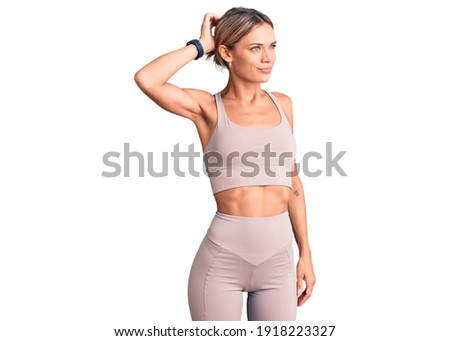 Beautiful caucasian woman wearing sportswear confuse and wondering about question. uncertain with doubt, thinking with hand on head. pensive concept. 